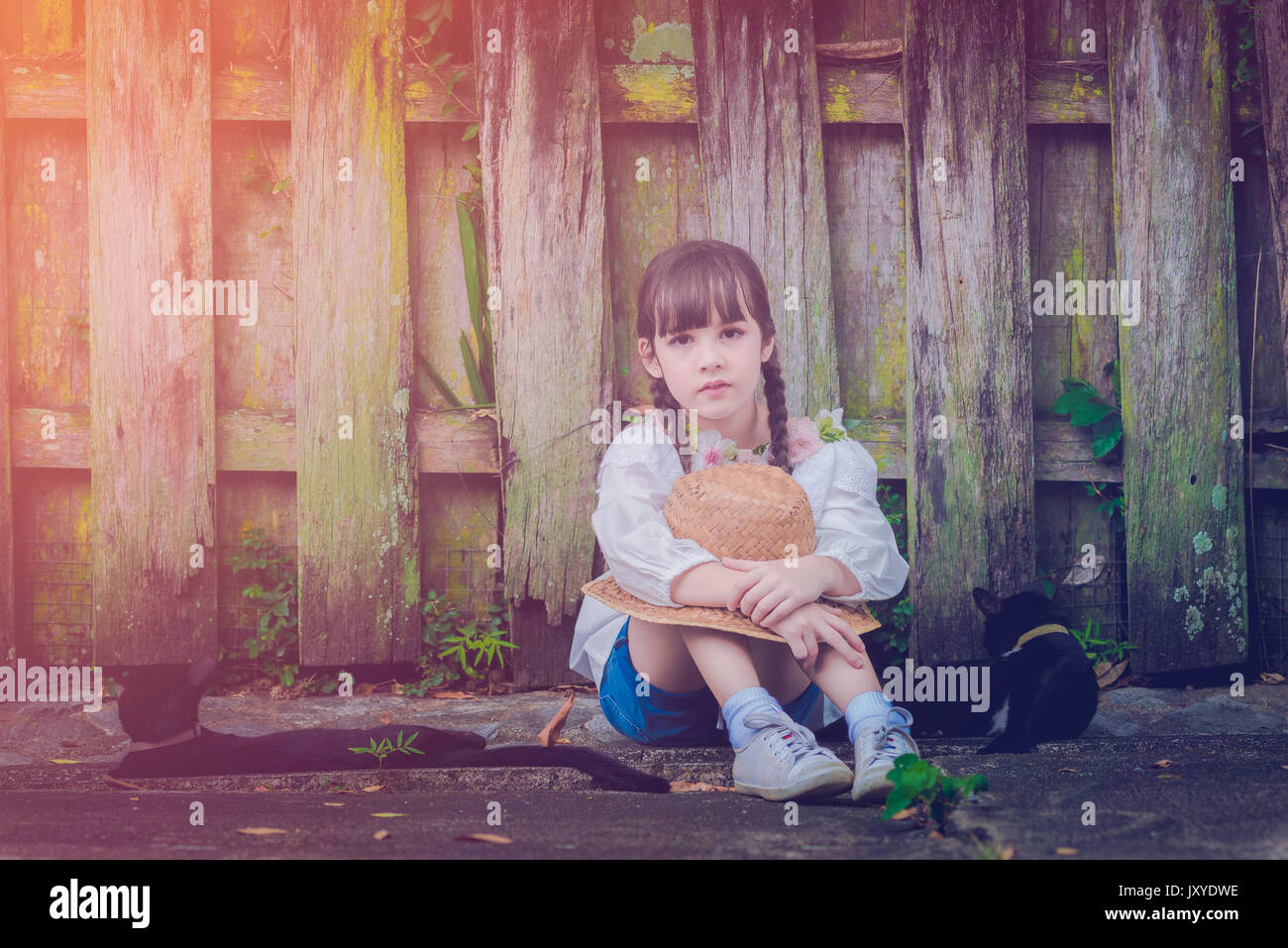 a little cute girl alone in the garden or farm and outside in nature Stock Photo