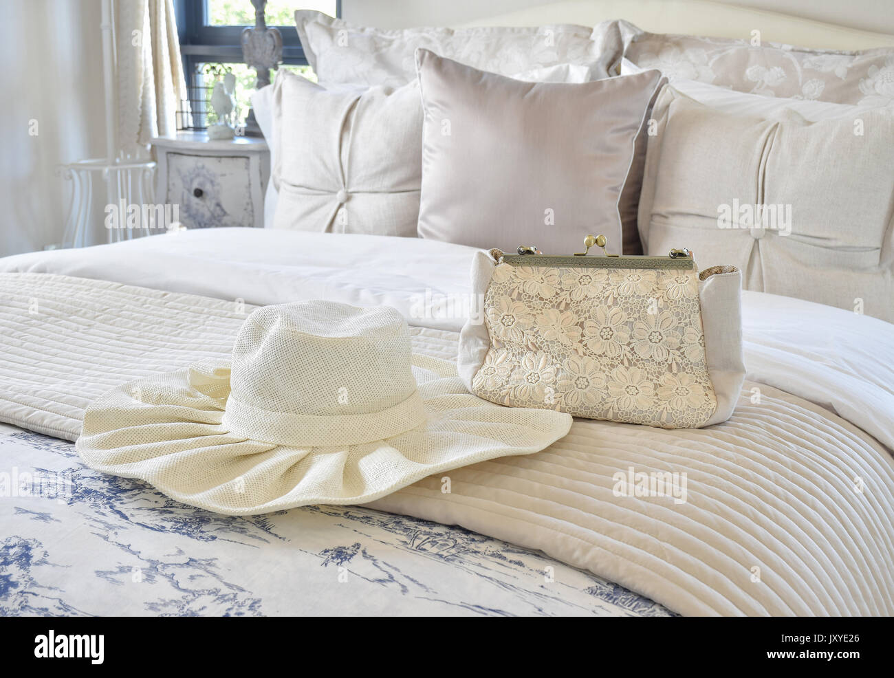 Decorative set with vintage bag and hat on bed in luxury bedroom