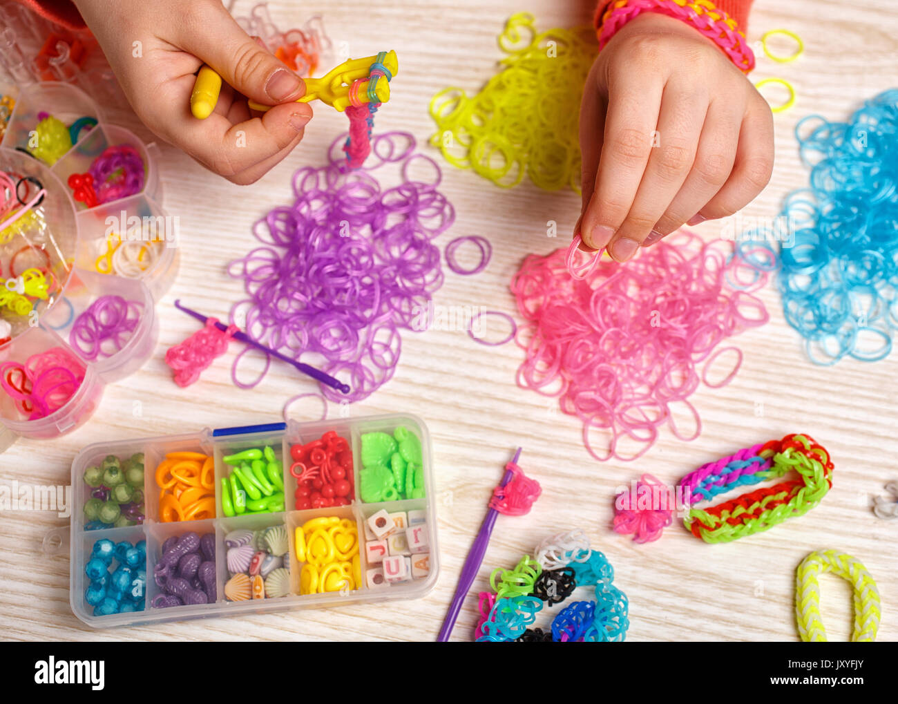 handwork, weaving rubber and effort concept - hands weaving of colored ...