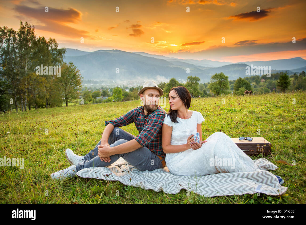 couple, love, nature and people concept - love young couple on a picnic in the mountains at sunset background. HDR foto Stock Photo