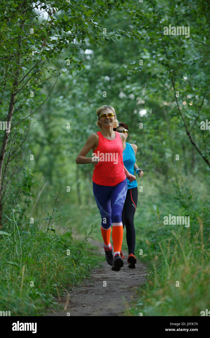 Two sportswomen training in woods Stock Photo