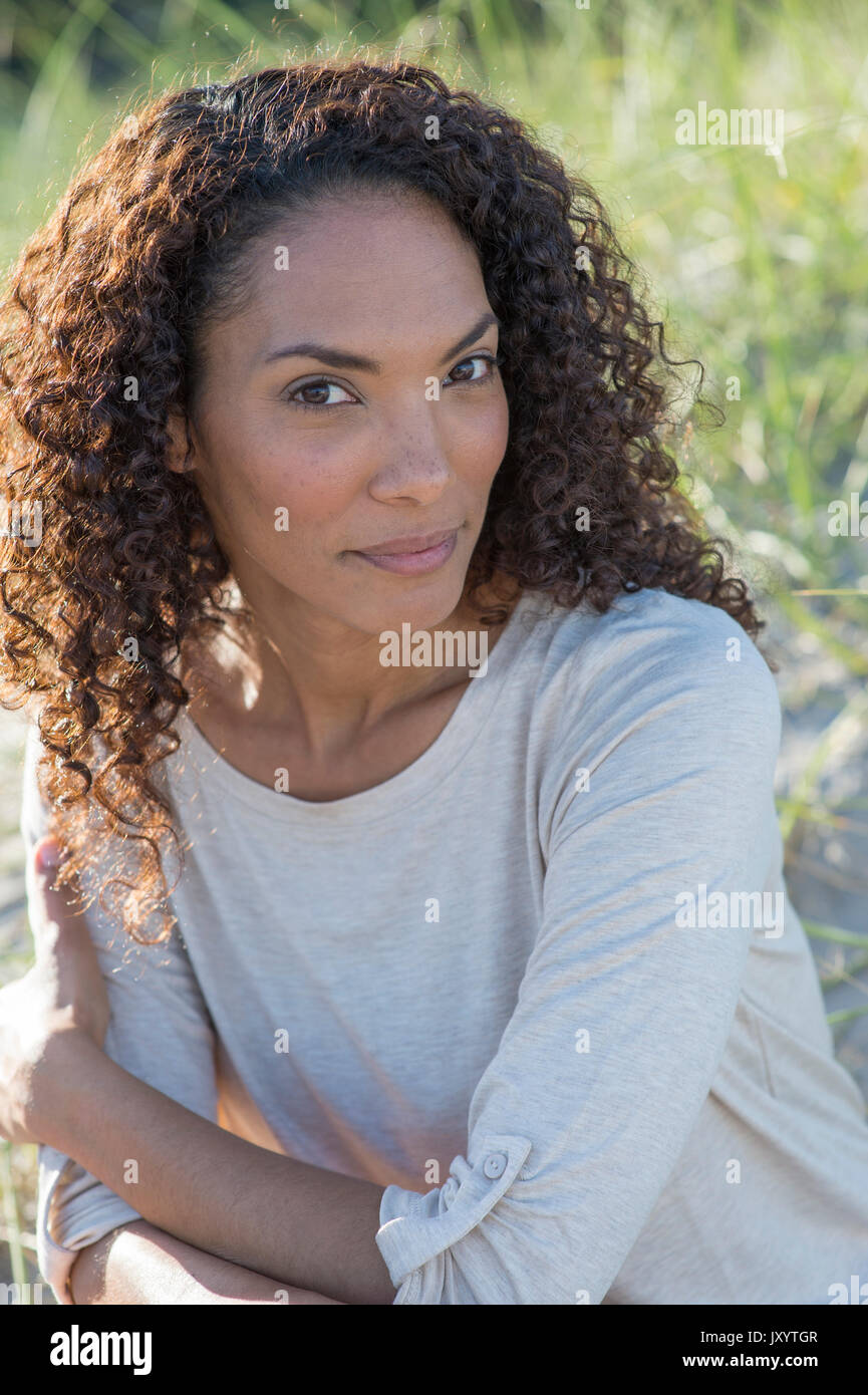 Portrait of smiling Mixed Race woman at beach Stock Photo