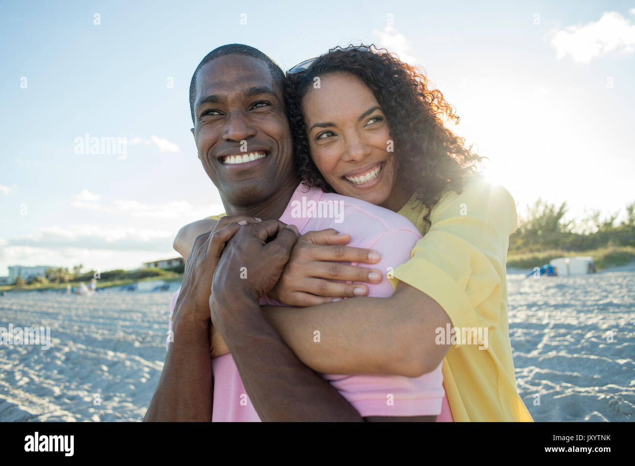 Portrait of smiling couple hugging on beach Stock Photo