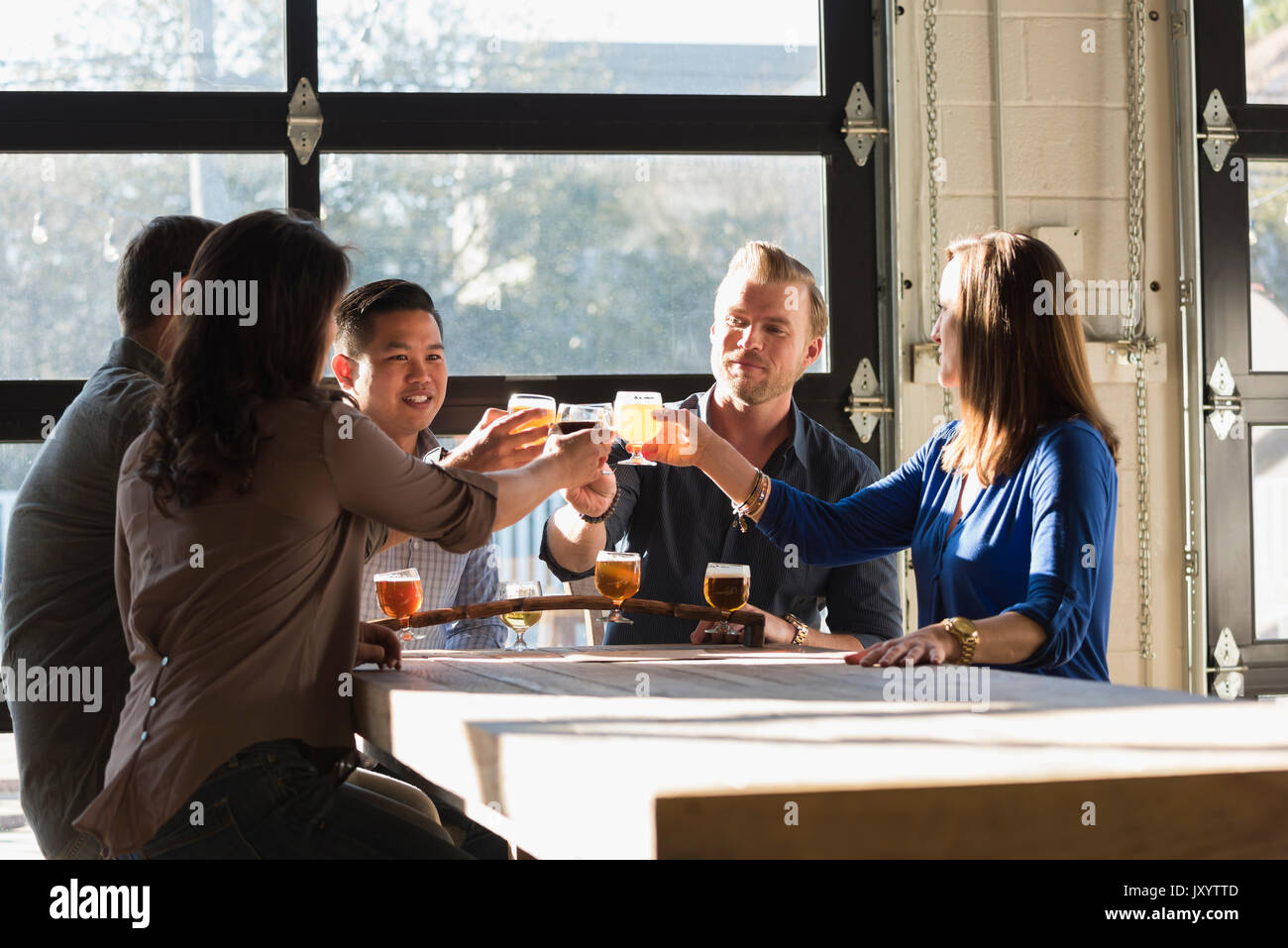 Friends toasting with beer in brew pub Stock Photo
