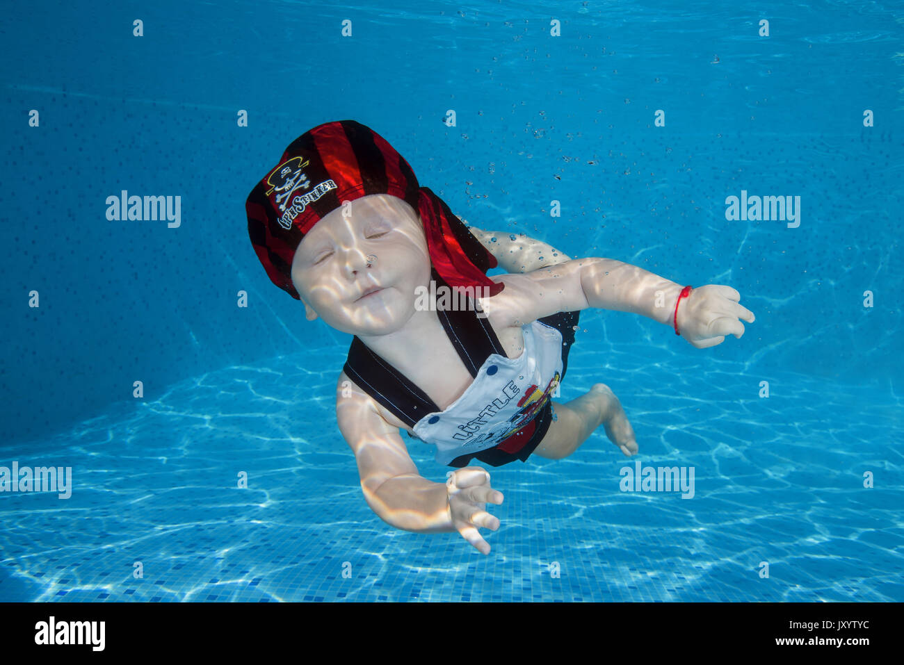 boy to swim in the pool. AMUSING shots show the exhilarated and confused faces water babies can pull when dunked into swimming pools this summer. The  Stock Photo