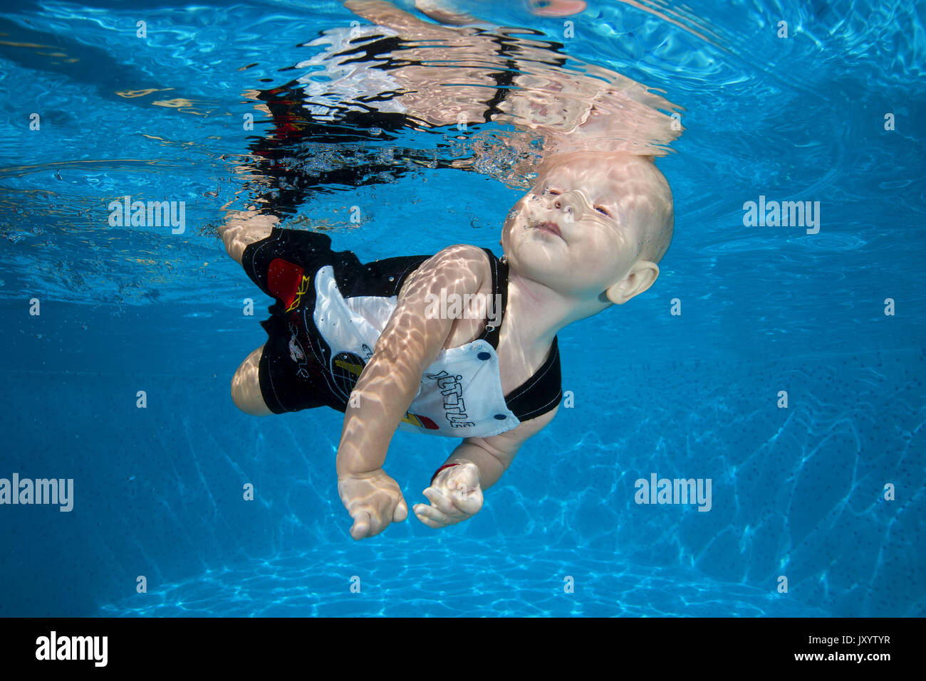 boy to swim in the pool 2. AMUSING shots show the exhilarated and confused faces water babies can pull when dunked into swimming pools this summer. Th Stock Photo