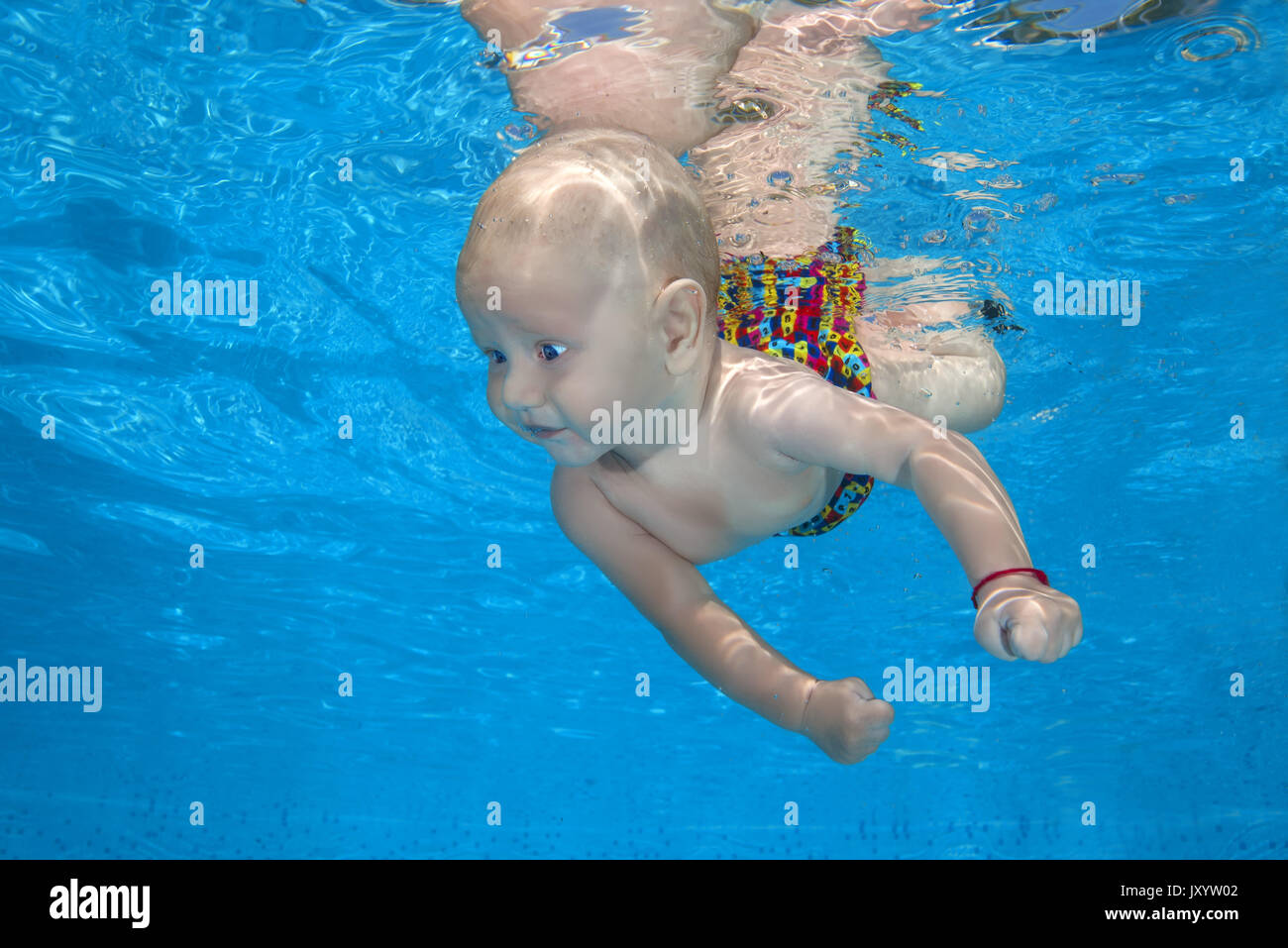 boy to swim in the pool 3. AMUSING shots show the exhilarated and confused faces water babies can pull when dunked into swimming pools this summer. Th Stock Photo