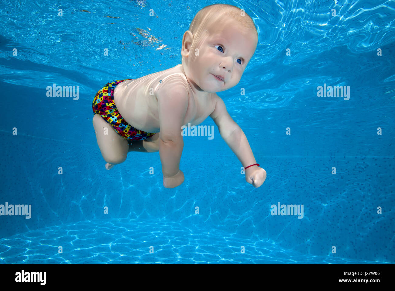 boy to swim in the pool 4. AMUSING shots show the exhilarated and confused faces water babies can pull when dunked into swimming pools this summer. Th Stock Photo