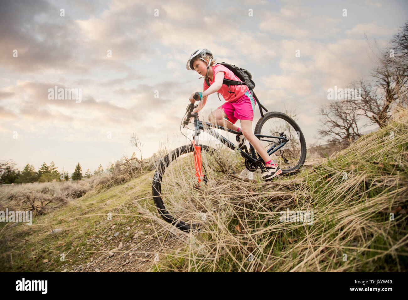 Caucasian girl riding bicycle on hill Stock Photo