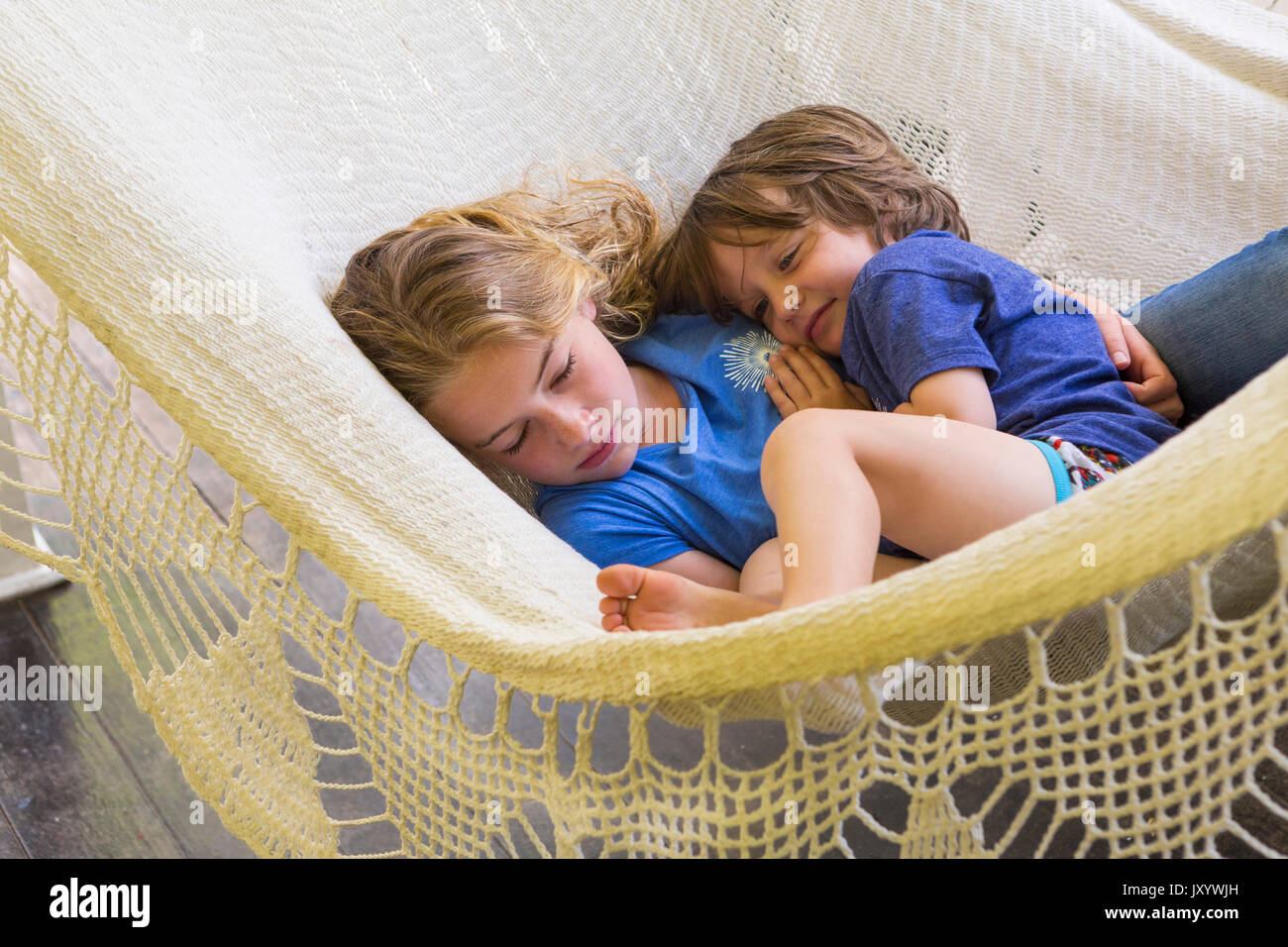 Caucasian brother and sister cuddling in hammock Stock Photo