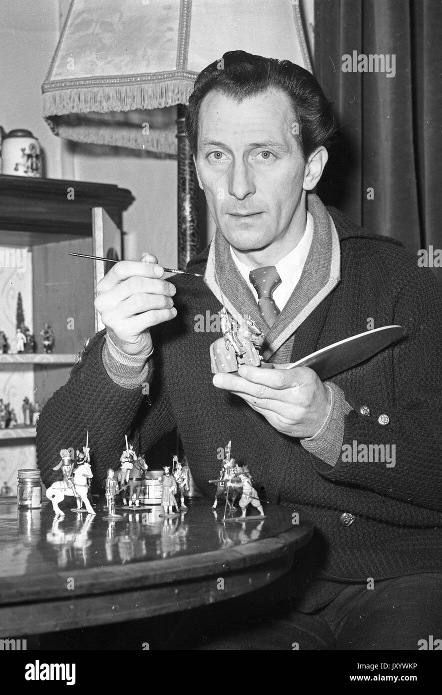 Film actor Peter Cushing painting his toy soldiers at his home in 1956 Stock Photo