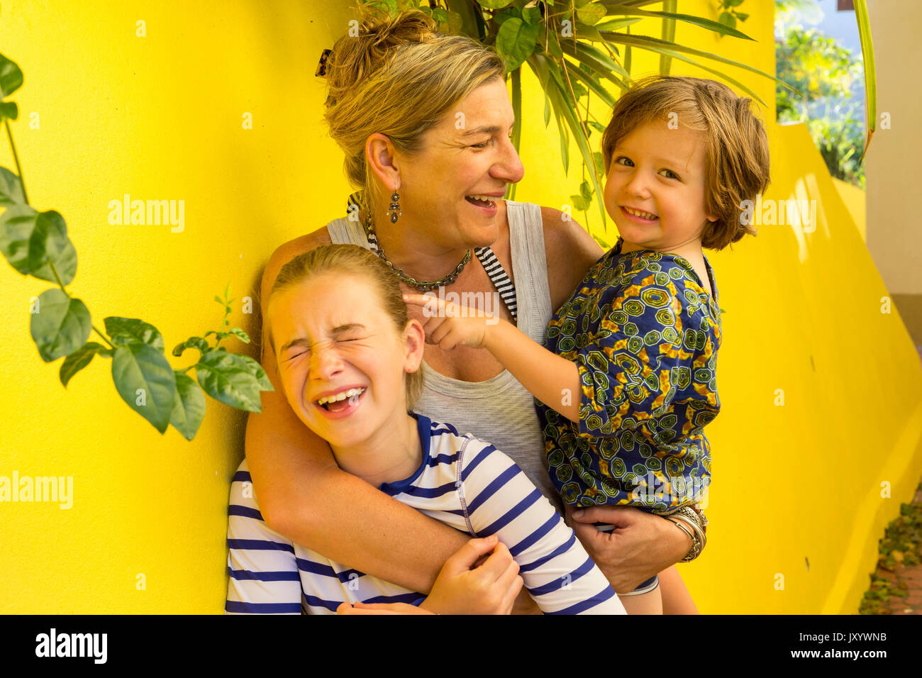 Laughing Caucasian mother hugging son and daughter Stock Photo