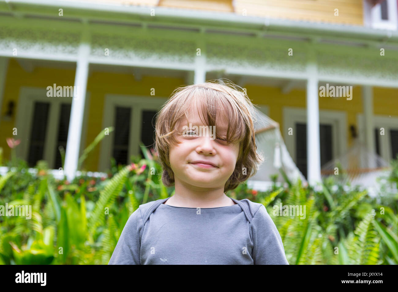 Smiling Caucasian boy in front of house Stock Photo