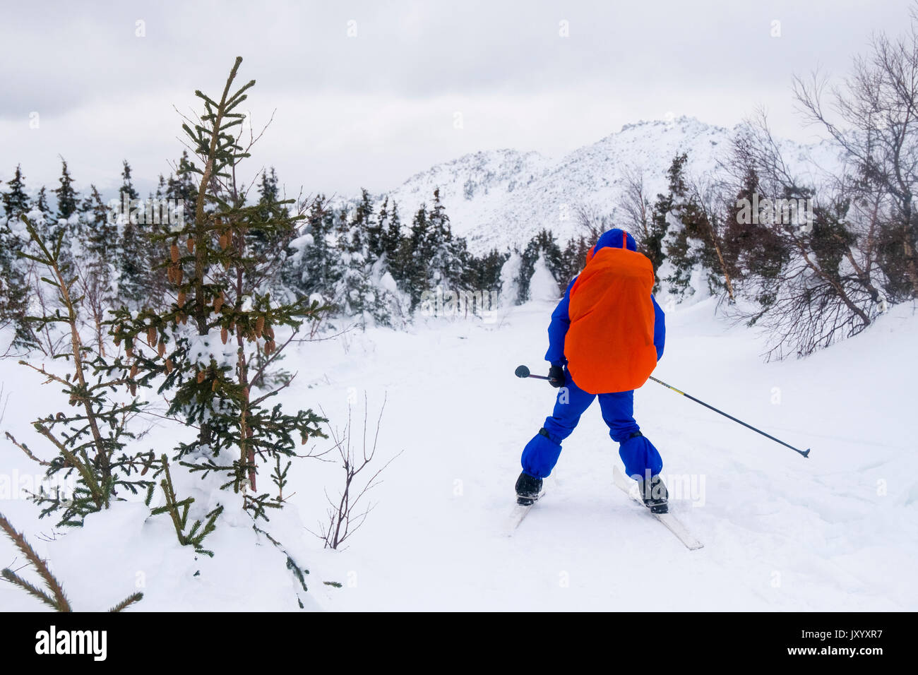 Caucasian man cross-country skiing near mountain Stock Photo