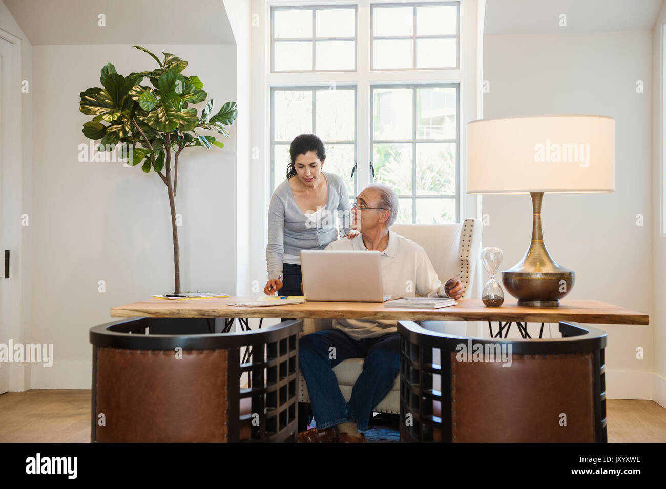 Older couple using laptop in home office Stock Photo