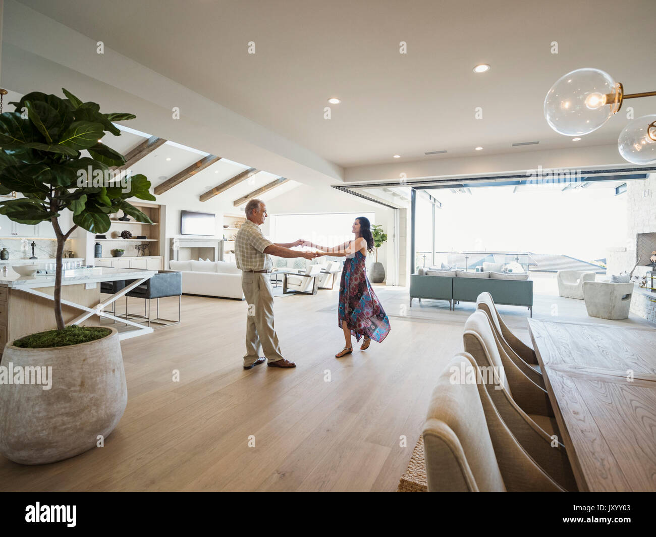 Older couple dancing in modern home Stock Photo