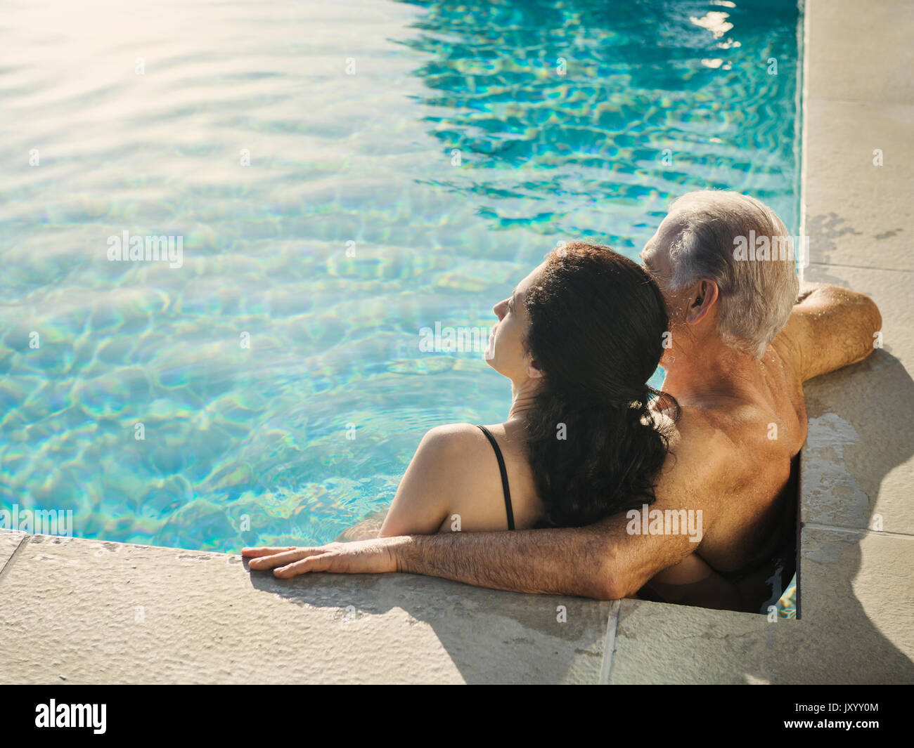 Older couple relaxing in swimming pool Stock Photo