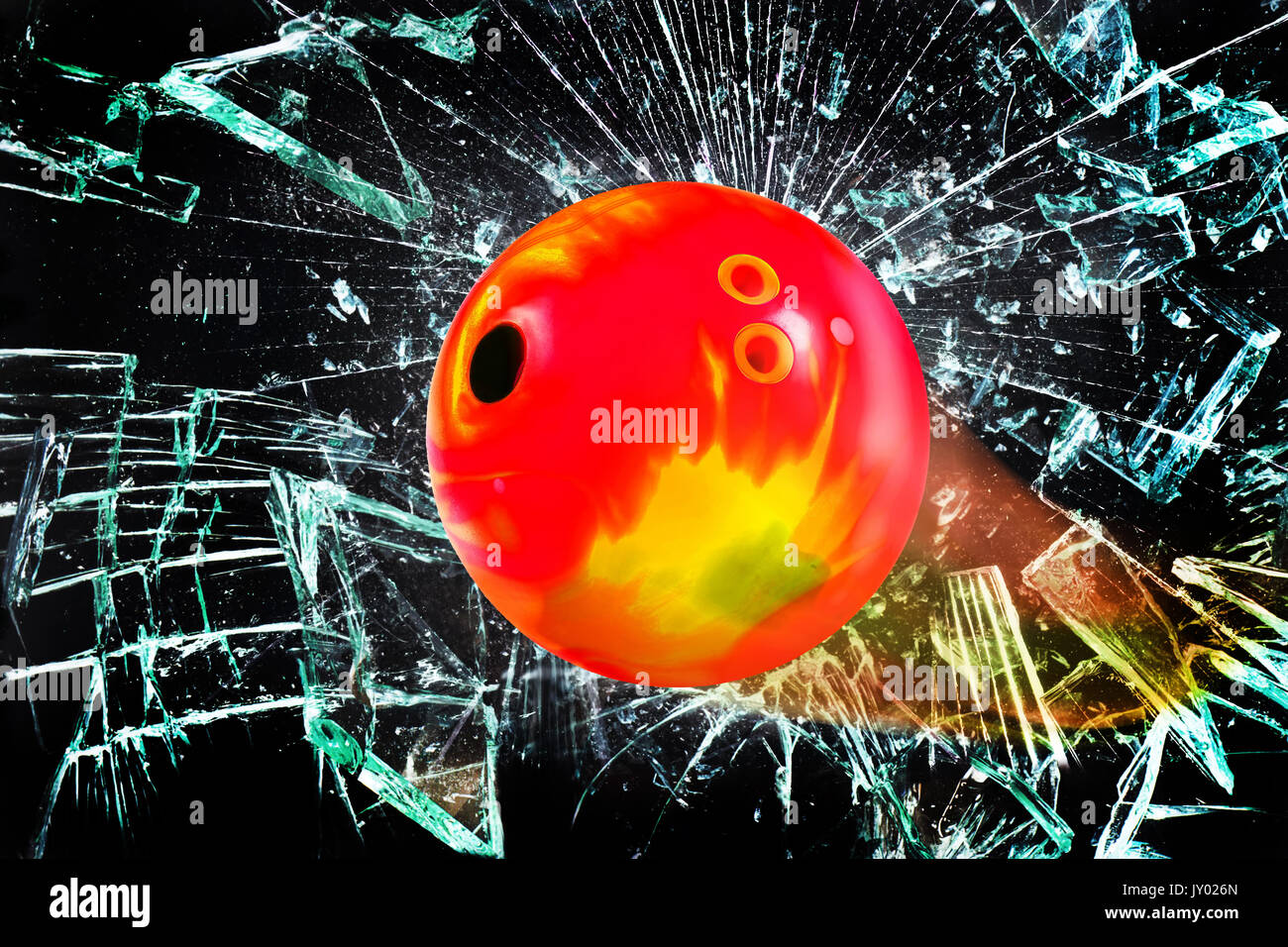 Bowling ball going through broken glass window. Stock Photo
