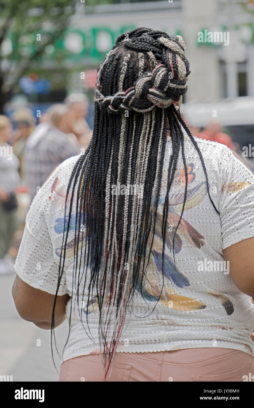 A view from the rear of a woman with three colors of hair extensions beautifuly braided. In lower Manhattan, New York City. Stock Photo