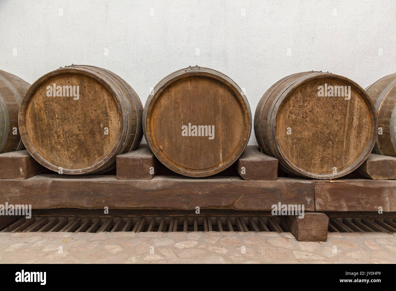 Old oak barrels lie in basement on wooden logs,old wine cellars with bottles and barrels Stock