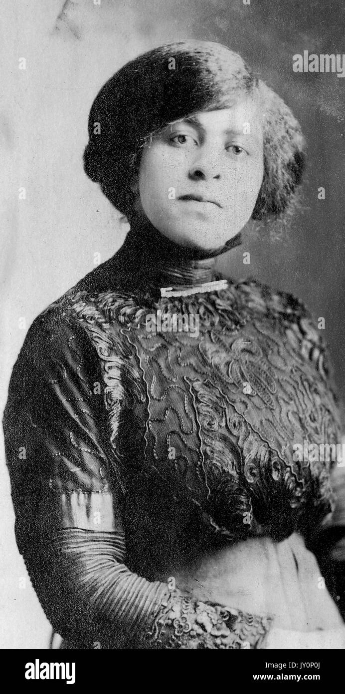 Half length portrait of mature African American woman, wearing elaborate dark dress, neutral expression, 1915. Stock Photo