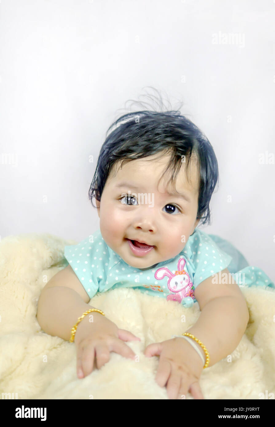 Asian Smiling baby girl crawling in bedroom Stock Photo