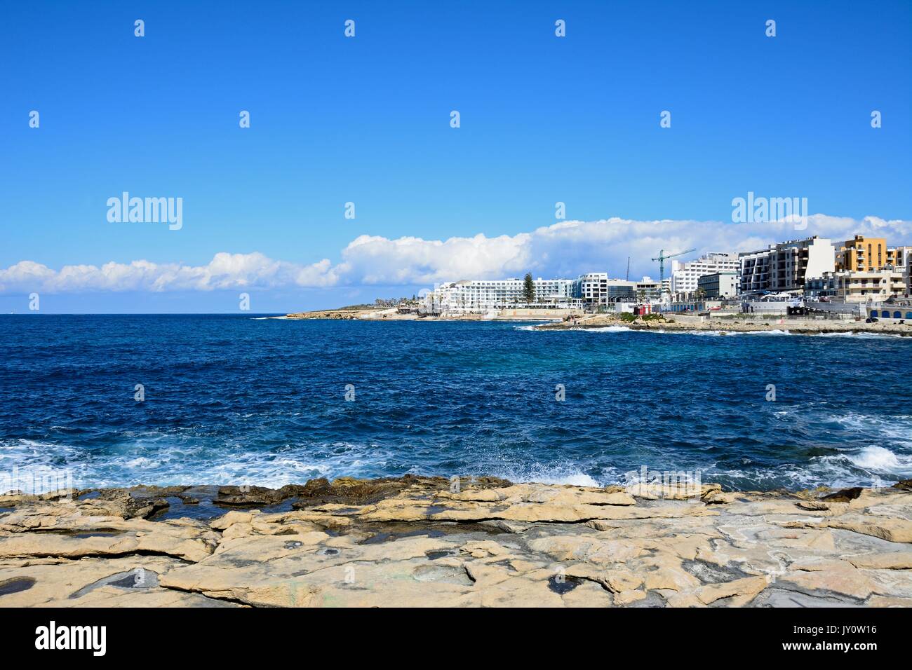 View of the rocky coastline with hotels and apartments to the rear, Bugibba, Malta, Europe. Stock Photo