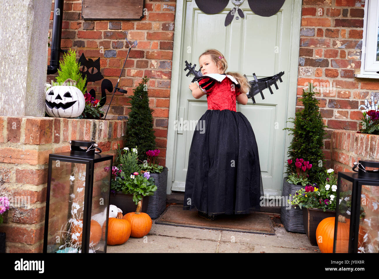 Young Girl Outside House Trick Or Treating Stock Photo
