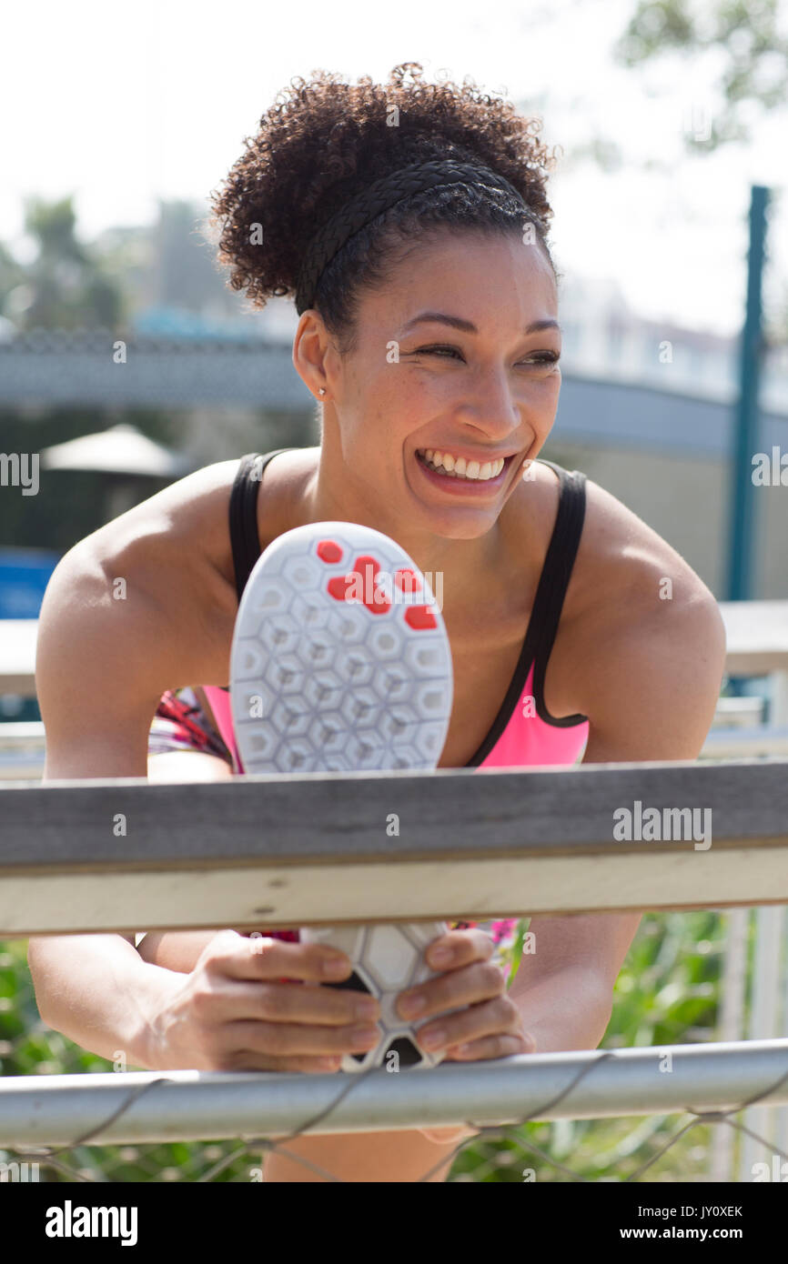 Mixed Race woman stretching leg on banister Stock Photo