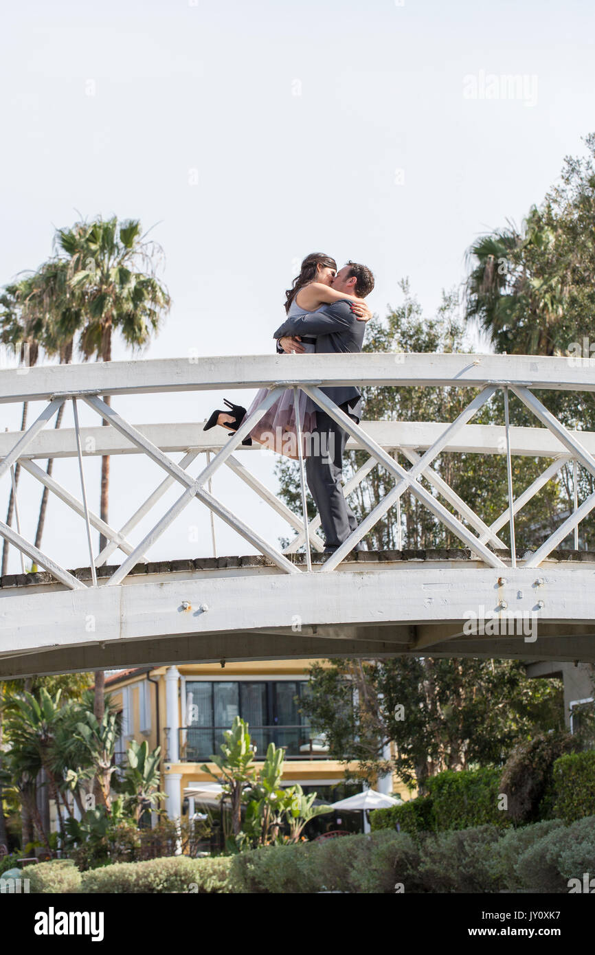 Kissing couple celebrating on bridge Stock Photo - Alamy