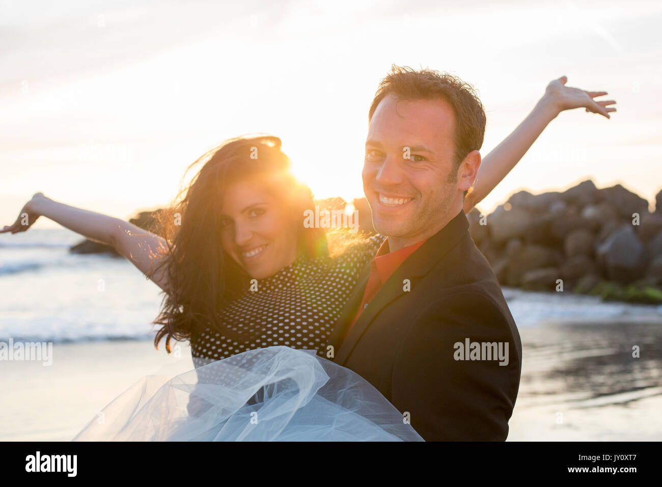 Portrait of couple celebrating on beach Stock Photo