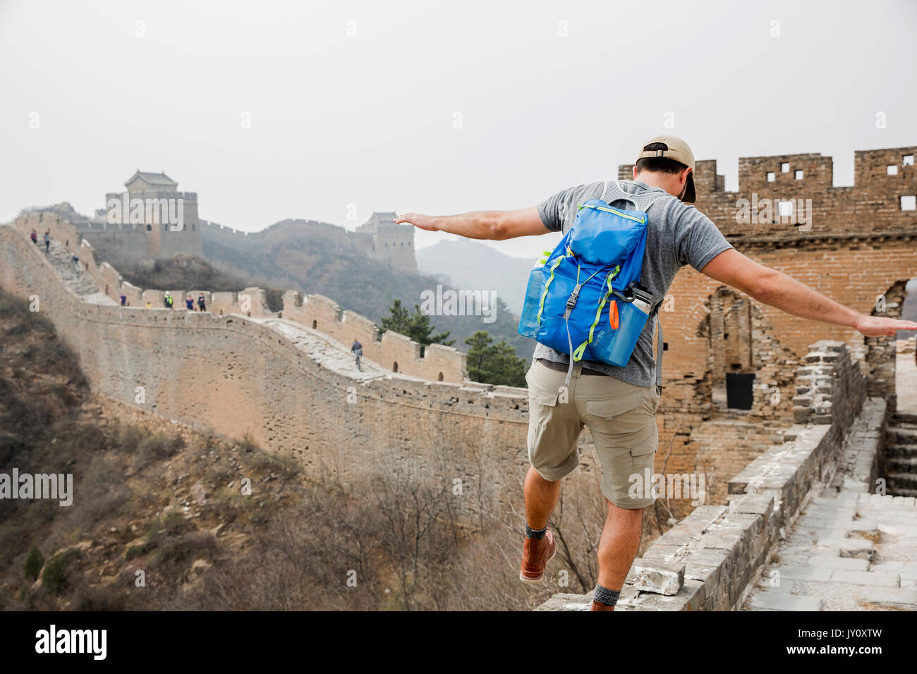 Tourist balancing on Great Wall of China, Beijing, China Stock Photo