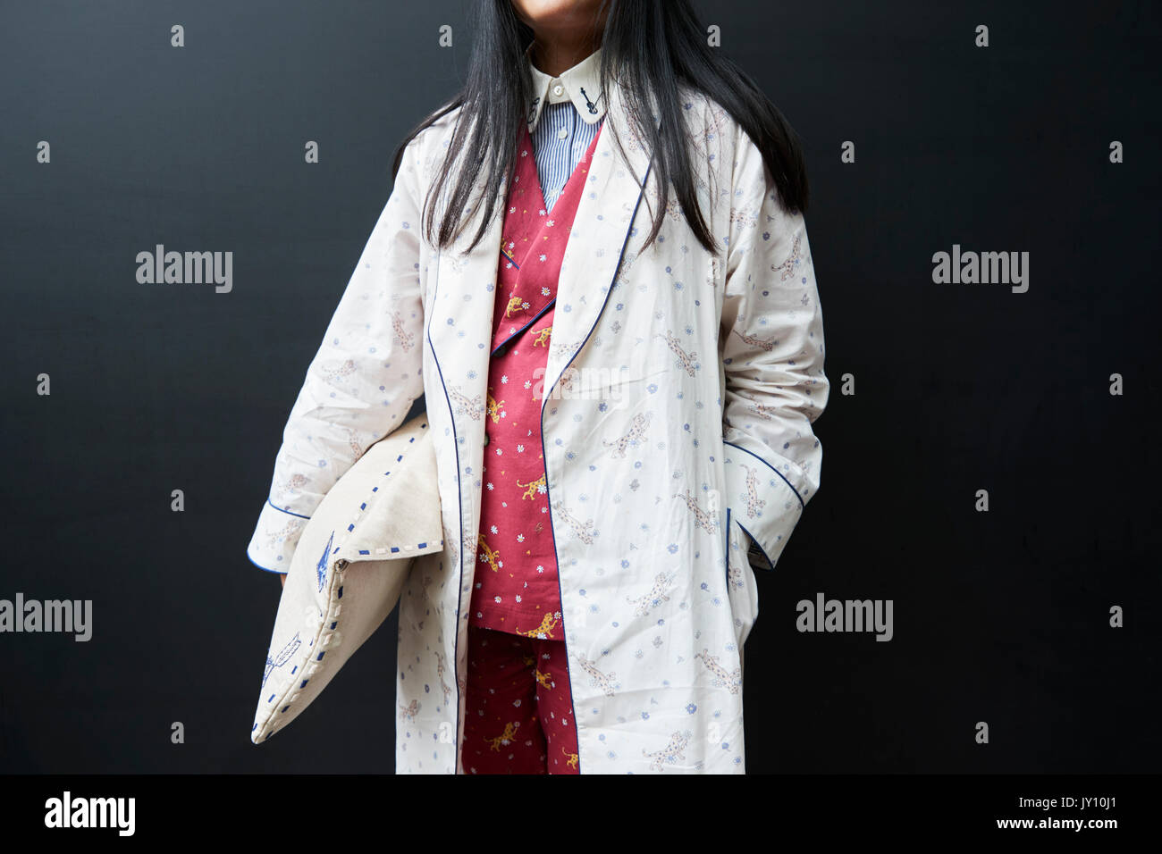 Person in pyjama suit and robe with pillow bag, mid section Stock Photo