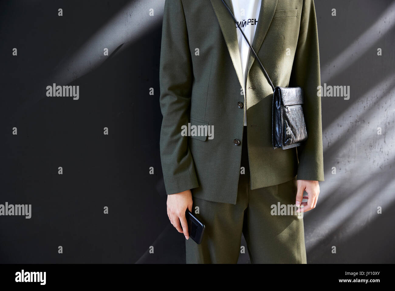 Mid section of a man in dark green suit with black bag Stock Photo