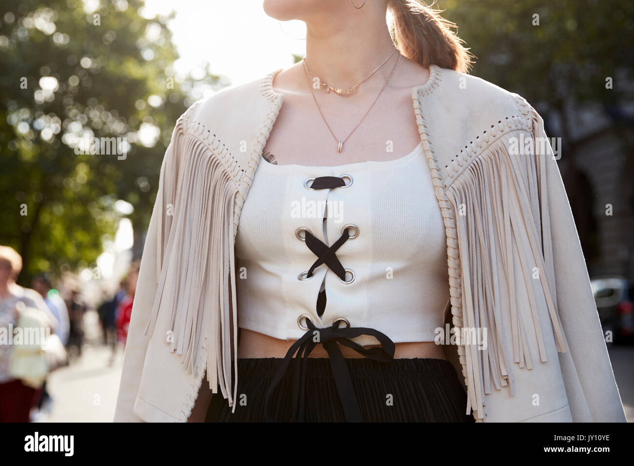 Woman in fringed jacket and laced up white top, close up Stock Photo