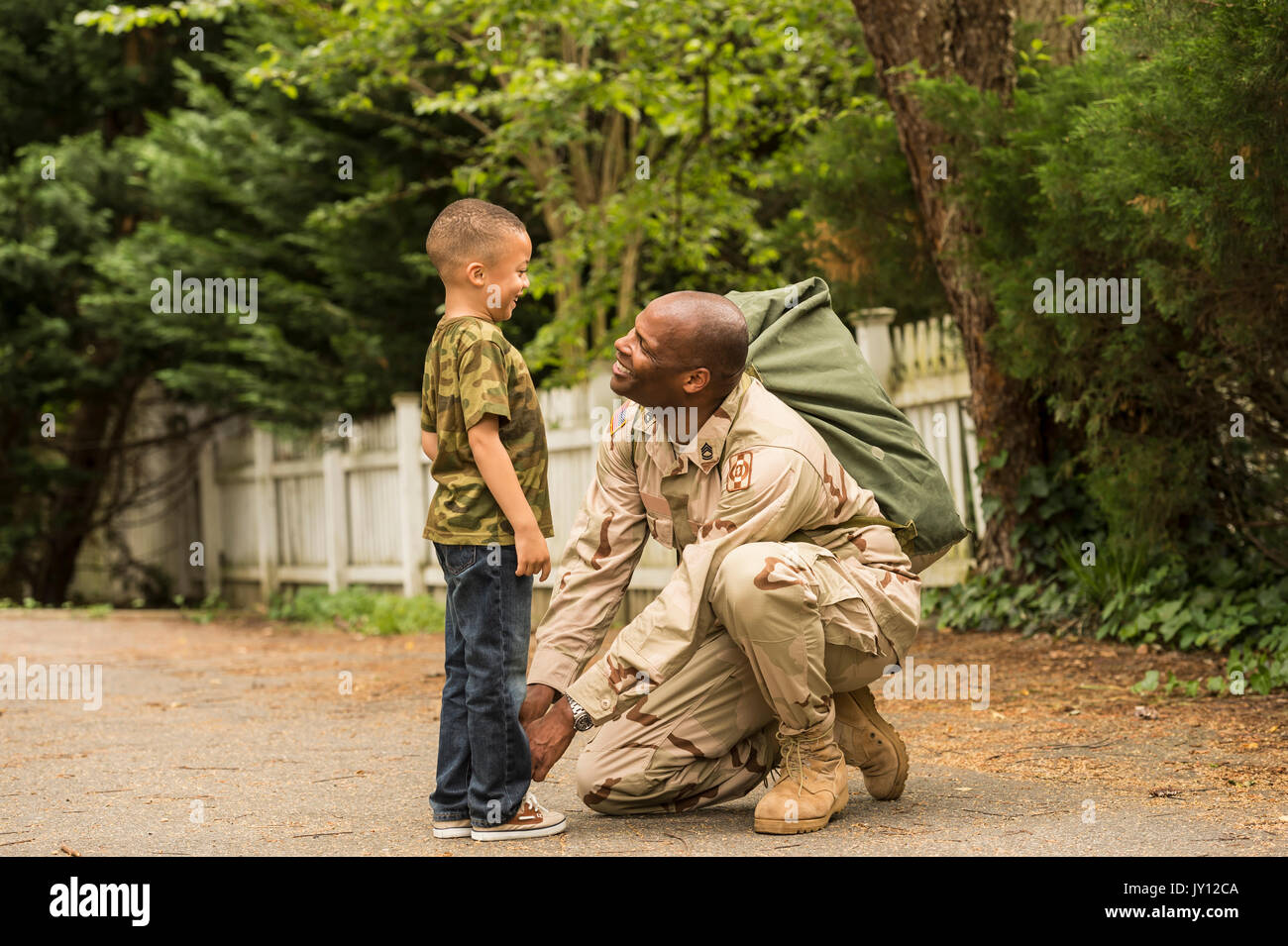 African American soldier tying shoelace for son Stock Photo
