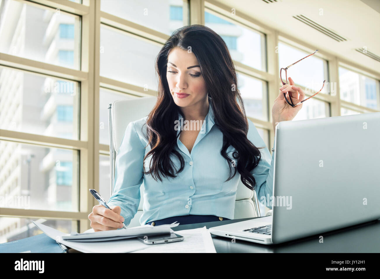 Caucasian businesswoman writing on paperwork Stock Photo