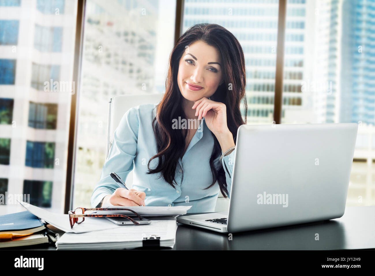 Caucasian businesswoman writing on paperwork Stock Photo