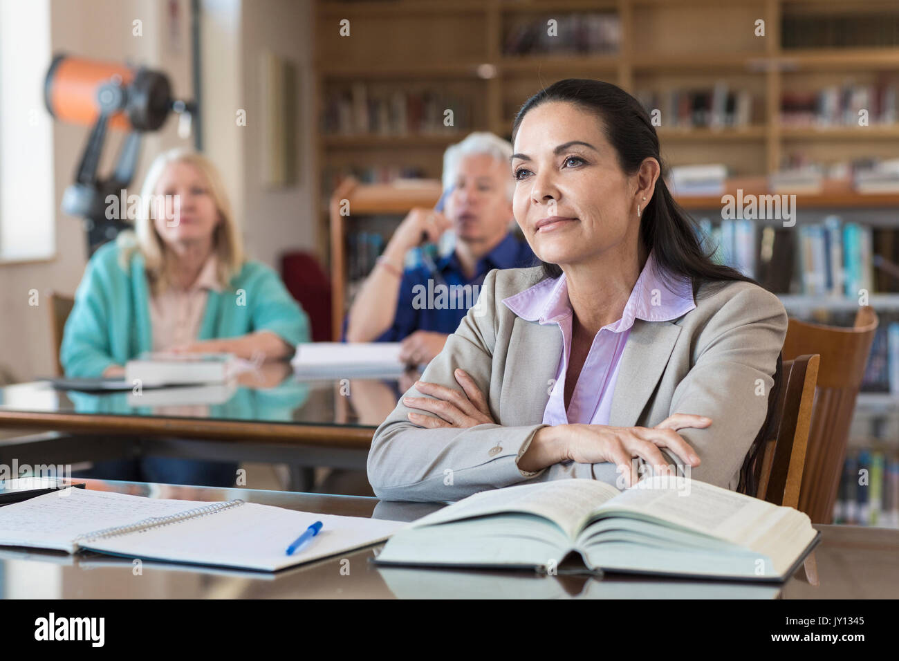 Curious older woman listening in library Stock Photo