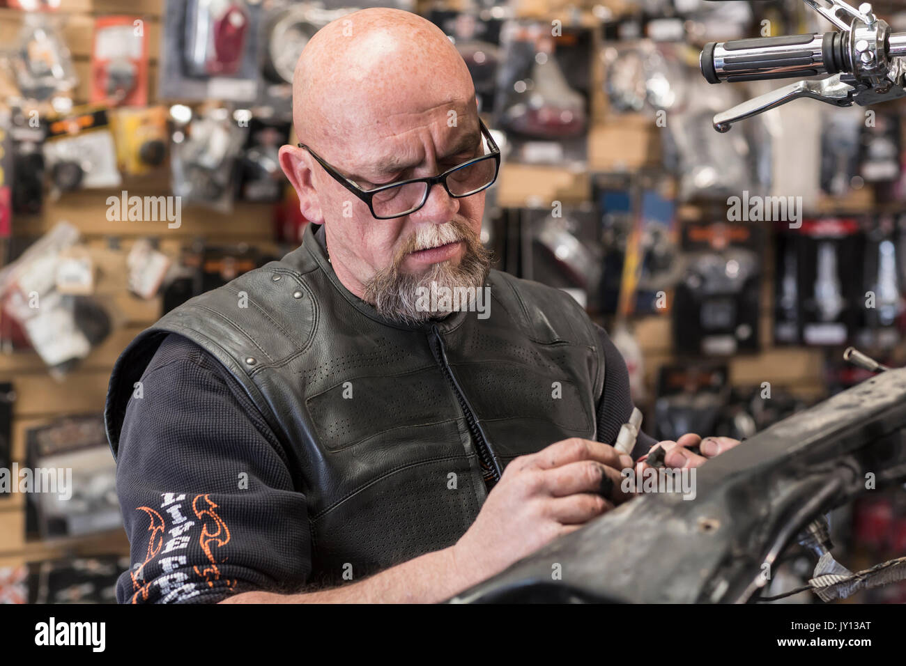 Caucasian man repairing motorcycle Stock Photo