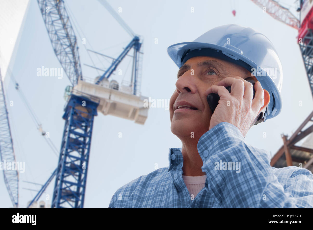 Hispanic construction worker talking on cell phone Stock Photo