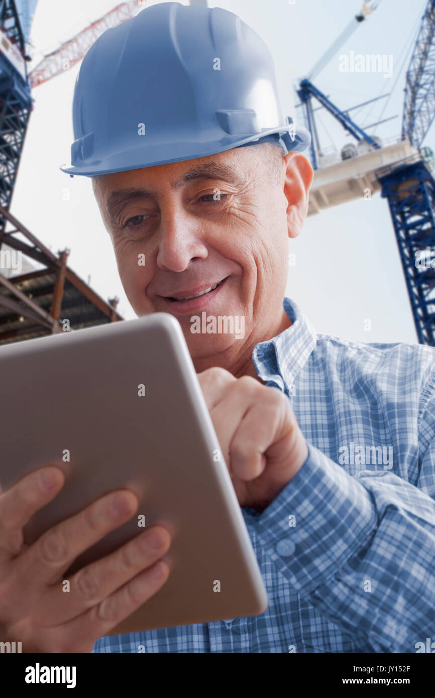 Hispanic construction worker using digital tablet Stock Photo