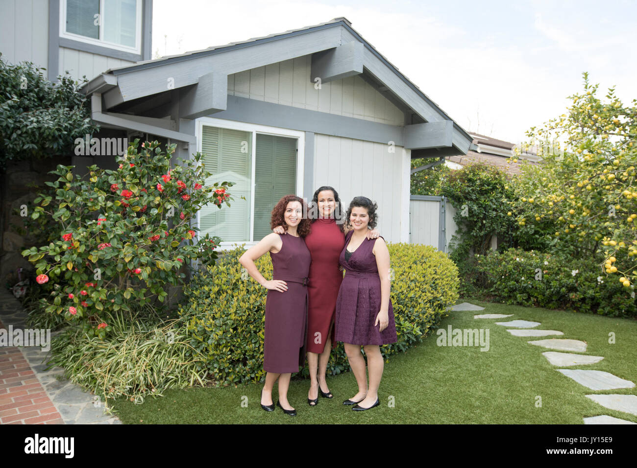 Mother and daughters posing near house Stock Photo Alamy