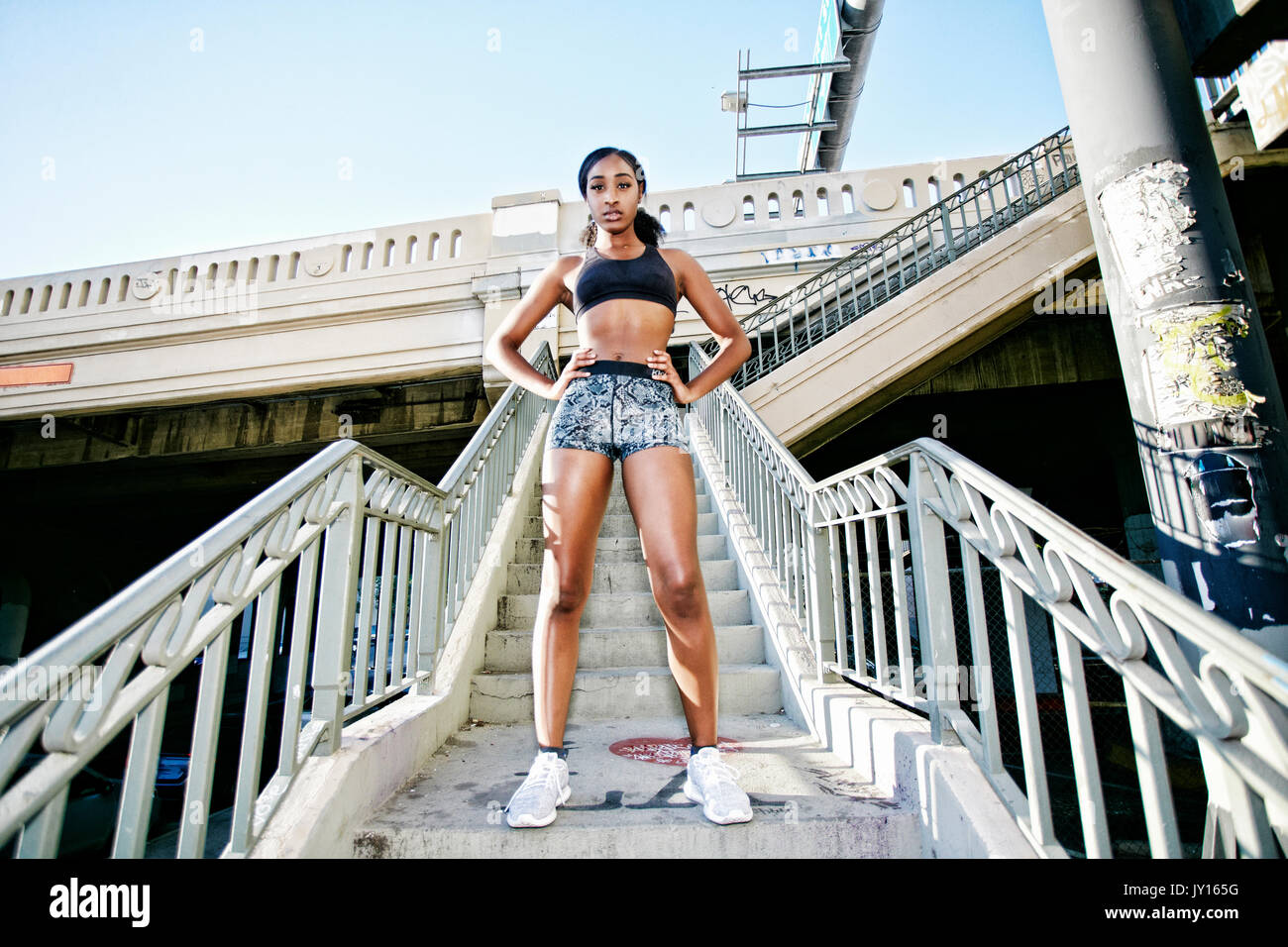 Serious Mixed Race woman standing on urban staircase Stock Photo