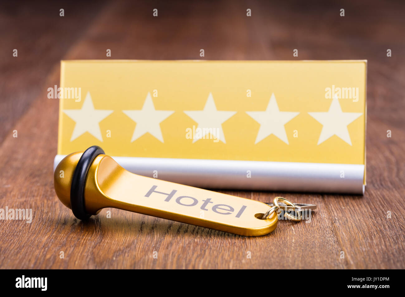 Hotel Key Is Placed Near Five Star Shape Card On Wooden Desk In Hotel