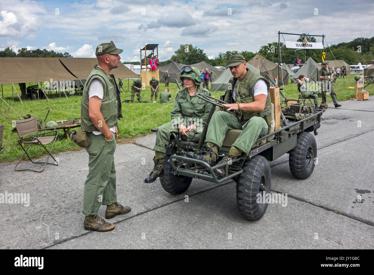 M274 Mechanical Mule and reenactors in US soldier outfits in military field camp during Vietnam War reenactment at militaria fair Stock Photo