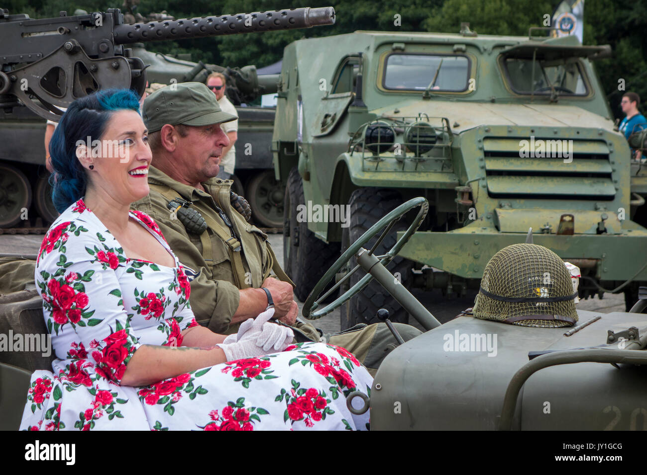 Reenactors dressed as WW2 US soldier and woman in 1940s dress posing in WWII military Willys MB jeep during World War Two militaria fair Stock Photo