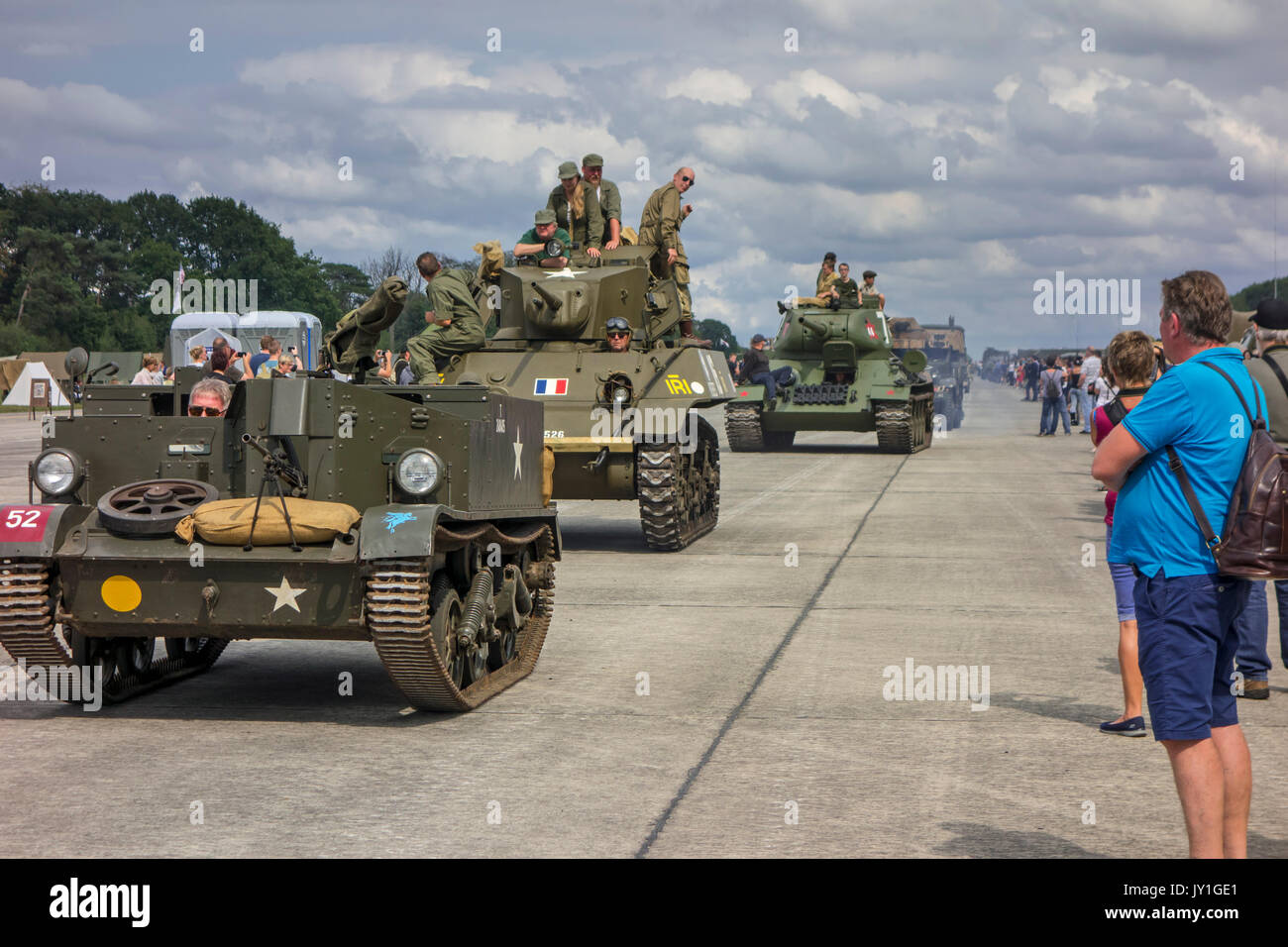 Visitors looking at parade of WW2 military armoured vehicles at World War Two militaria fair Stock Photo