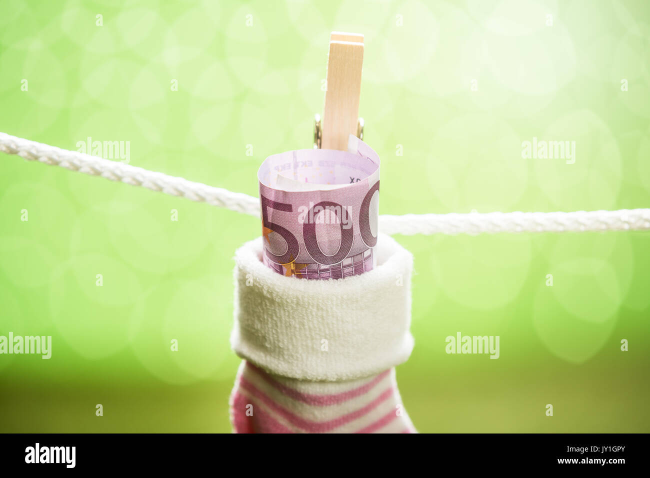 Baby Sock With Dollar Hanging On Rope Using Wooden Clip Stock Photo