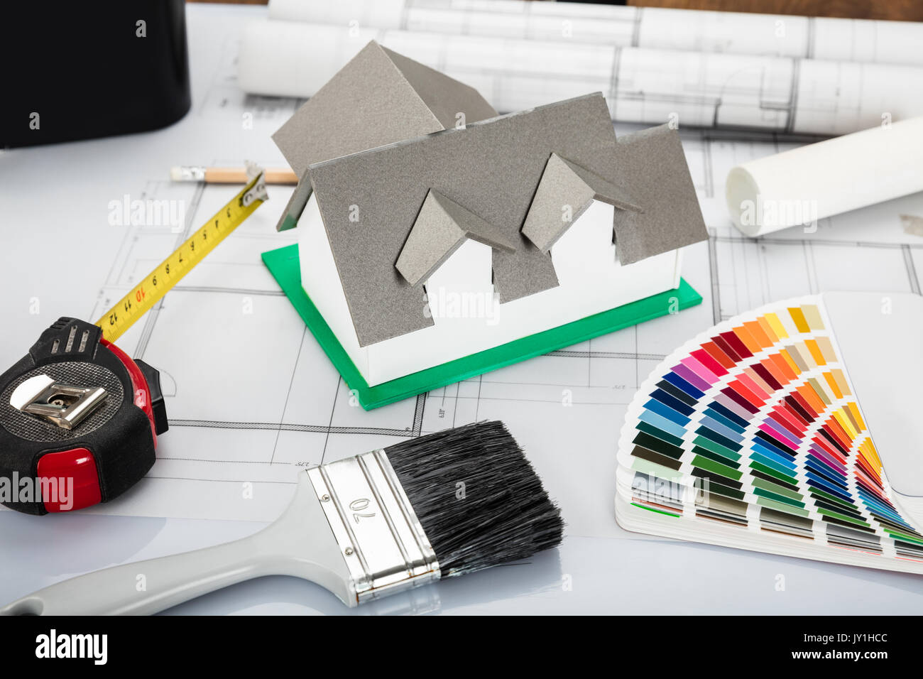 High Angle View Of House Model With Blueprint And Other Materials On Office Desk Stock Photo